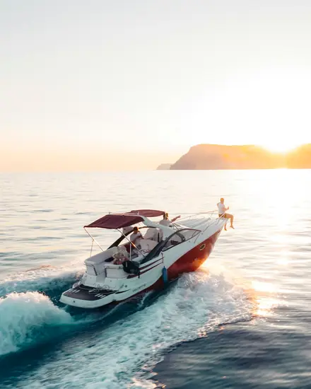 Lancha navegando no mar ao pôr do sol